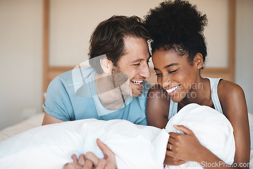 Image of Happy couple, bed and laughing in relax for morning, bonding or intimate relationship at home. Interracial man and woman smiling with laugh in joyful happiness or relaxing weekend together in bedroom