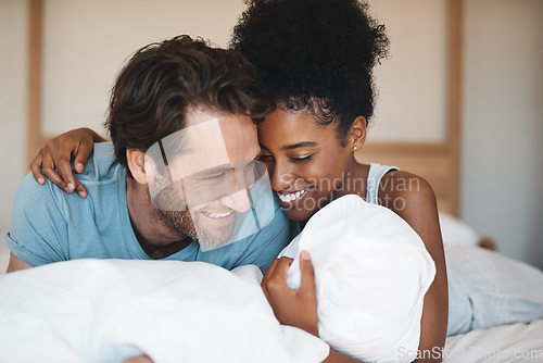 Image of Happy couple, bed and hug laughing in relax for morning, bonding or relationship at home. Interracial man and woman smiling, hugging and laugh in happiness or relaxing weekend together in bedroom