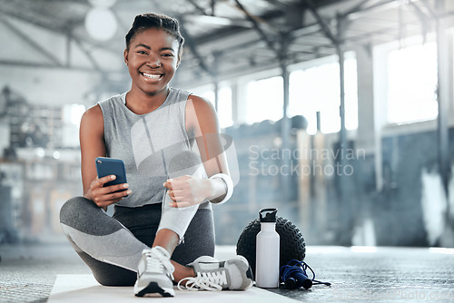 Image of Social media, smile or black woman with phone in gym to search for sports online in training or exercise. Fitness app, happy or healthy athlete relaxing or resting online mobile content on break