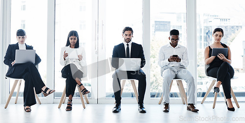 Image of Group, business people and chair with tech in recruitment queue, diversity or waiting room for hr. Men, women and technology for interview, human resources and research for hiring, job or opportunity