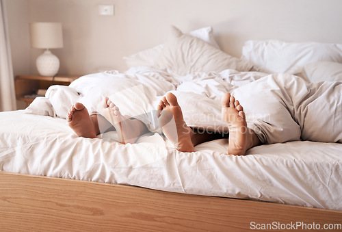 Image of Sleep, bedroom legs and tired couple relax at home, cozy and peace for morning health, wellness and fatigue. Blanket, feet and exhausted man, woman or people sleeping for comfort in apartment bed