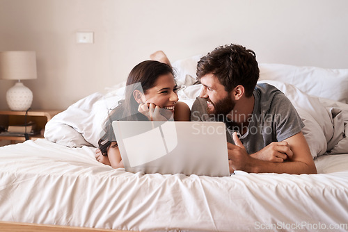 Image of Bed, laptop and happy couple relax, smile and excited for for web info, morning blog or website notification. Home bedroom, eye contact and people bond, doing online shopping or internet search