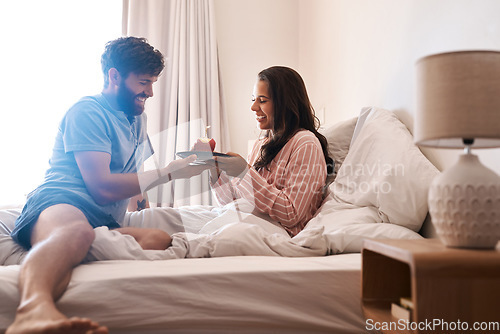 Image of Happy couple, bedroom and birthday muffin, morning dessert or celebration food for excited woman. Cupcake candle, surprise sweets and fun people smile, happiness and celebrate special day on home bed