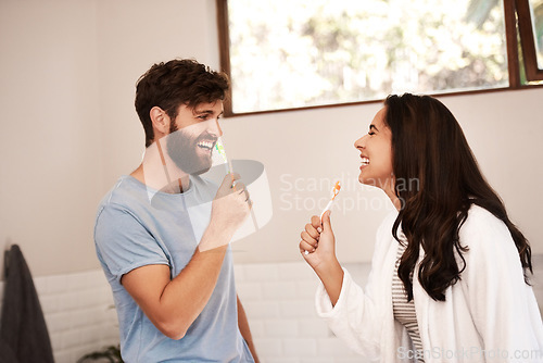 Image of Brushing teeth, home bathroom and happy couple singing music song with toothbrush, having fun and bonding. Self care, morning singer and people cleaning mouth for health, hygiene or dental wellness