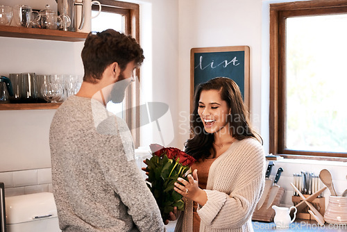 Image of Roses, kitchen and happy couple with surprise flowers, floral present and flower bouquet for Valentines Day celebration at home. Birthday, smile and romantic man with gift for marriage anniversary