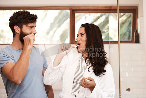 Image of Dental, home bathroom and happy couple brushing teeth with toothbrush, toothpaste and morning self care. Tooth, enamel care routine and people cleaning mouth for health, hygiene or oral wellness