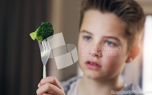 Image of Disgust, food and refuse with child and broccoli for nutrition, health and cooking. Sad, angry and dinner with boy and green vegetable on fork at home for eating problem, frustrated and dislike