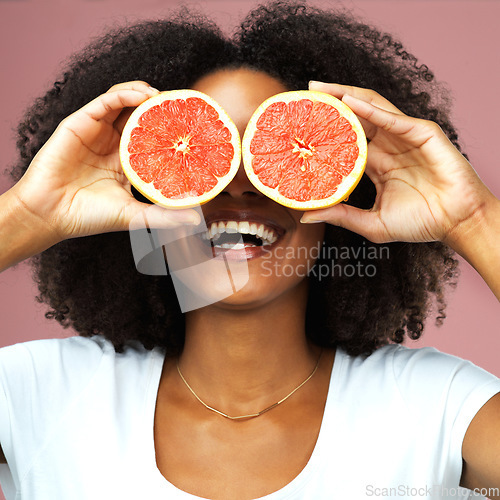 Image of Grapefruit, happy and black woman covering her eyes in studio isolated on a pink background. Funny, fruit and African female model with vegan nutrition, vitamin c or healthy diet, food and wellness.