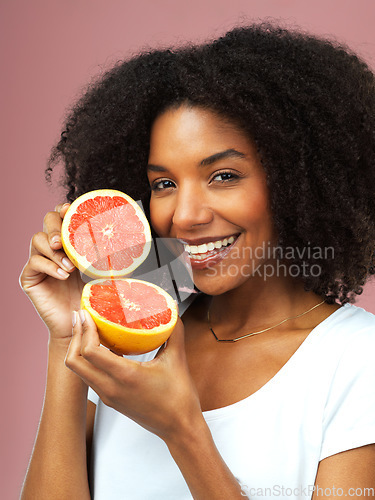 Image of Grapefruit, happy and portrait of woman in studio isolated on a pink background, citrus detox or natural wellness. Face, fruits and african female model with vegan beauty, vitamin c and healthy diet