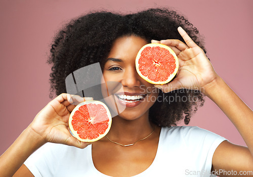 Image of Grapefruit, smile and face portrait of black woman in studio isolated on a pink background. Natural, fruit and African female model with vegan nutrition, vitamin c or healthy diet, food or wellness.