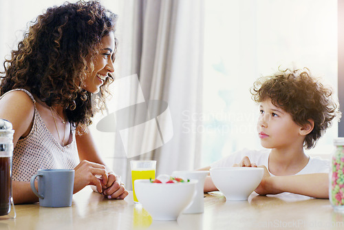 Image of Family, breakfast and kid with mother at morning in a home with happiness and orange juice with care. Mom, food and young child together with love and support with healthy drink and youth with smile
