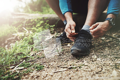 Image of Tying laces, fitness and hands in nature to start walking, adventure or trekking for exercise. Shoes, sports and feet of a man getting ready for cardio, training or a walk for a workout in a park