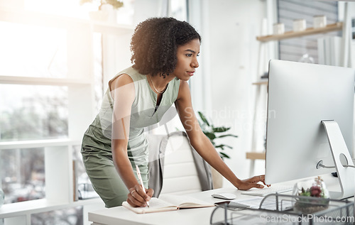 Image of Computer, planner and business woman writing in a notebook or working by her desk or table in startup. Internet, online and professional female employee or worker planning company schedule