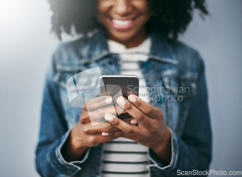 Image of Hands, phone and woman with typing by wall background with excited smile, notification and meme on web chat. Closeup gen z girl, smartphone and texting for blog, post and video on social network app