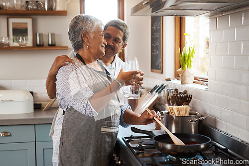 Image of Cheers, wine and old couple at in kitchen cooking food together at stove with smile, love and romance. Toast, drinks and senior woman with man, glass and happiness to make dinner meal in retirement
