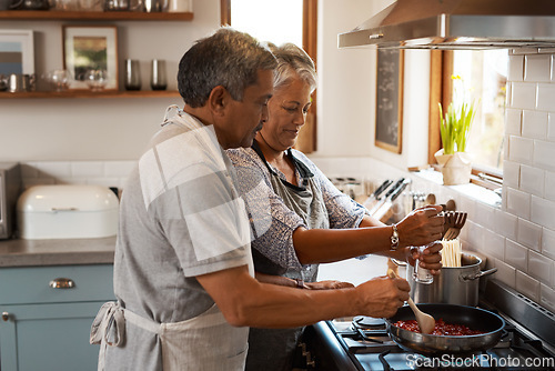 Image of Cooking food, help and old couple in kitchen with smile, meal prep and frying at stove together. Love, senior woman helping elderly man prepare lunch in pan, retirement and dinner time in modern home