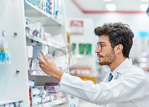 Image of Pharmacist, reading medicine and man in pharmacy while working in store for retail career. Male person in pharmaceutical or medical industry for service, healthcare and inventory check on shelf