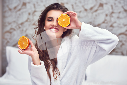 Image of Orange, beauty and happy with woman in hotel for breakfast, diet and relax. Nutrition, health and natural with female person and cover face with citrus fruit in bedroom for vitamin c, spa and facial