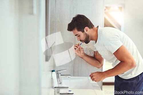 Image of Dental, cleaning and brushing teeth with man in bathroom for habit, morning routine and oral hygiene. Smile, cosmetics and health with person and toothbrush at home for self care, breath and mouth