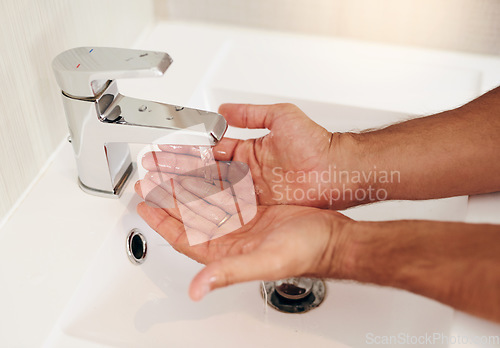 Image of Tap, water and person cleaning hands for skincare, personal grooming and safety of bacteria, healthy and dermatology. Closeup, palm and washing hand at basin in bathroom for hygiene routine at home