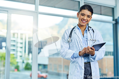 Image of Portrait, doctor and smile of woman with tablet in hospital for research, telehealth or healthcare. Face, happiness and female medical professional with touchscreen tech for online wellness in clinic