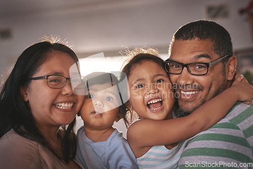 Image of Portrait, laugh and happy family hug in a living room, excited and bonding in their home together. Face, children and parents in a lounge embrace, relax and laughing at funny, comedy and crazy joke