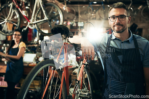 Image of Serious, portrait and mechanic man in bicycle shop working in store or cycling workshop for repair. Face, bike technician and confident male person, worker or mature professional with glasses.