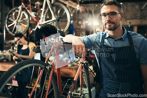 Image of Portrait, serious man and mechanic in bicycle shop, store and cycling repair startup. Technician service, bike and confident male person, mature worker and professional with glasses in workshop