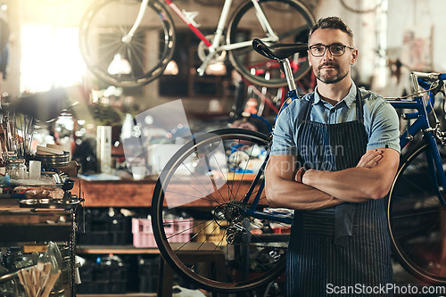 Image of Portrait, serious and repair man in bicycle shop with arms crossed in workshop. Face, bike mechanic and confident male person, professional or mature technician and glasses in store or small business