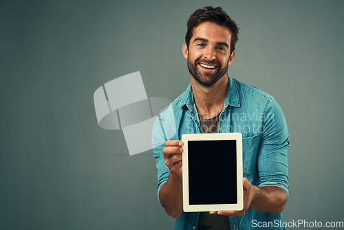 Image of Happy man, tablet and advertising screen on mockup for marketing or branding against a grey studio background. Male person with smile showing technology display or mock up space for advertisement