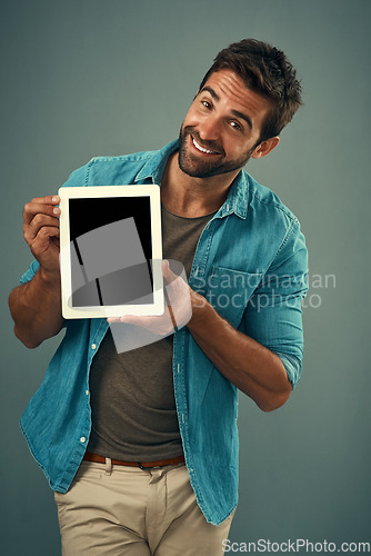 Image of Happy man, tablet and mockup screen for advertising, marketing or branding against a grey studio background. Portrait of male person showing technology display or mock up space for advertisement