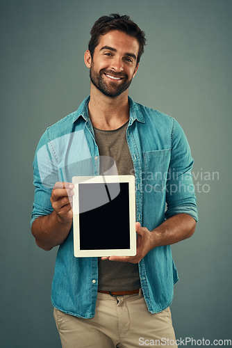 Image of Happy man, tablet and portrait with mockup screen for advertising or marketing against grey studio background. Male person with smile showing technology display or mock up space for advertisement