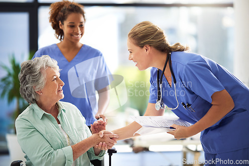 Image of Handshake, nurse and senior woman in wheelchair with medical results and surgery success news. Hospital, healthcare and clinic with women and nursing staff with care and support of elderly person