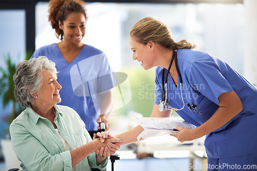 Image of Handshake, nurse smile and senior woman in wheelchair with medical results and surgery success news. Hospital, healthcare and clinic with women and nursing staff with care and help of elderly person