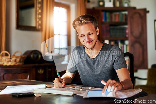 Image of College research, studying and a man with a tablet for home work, education and elearning. Smile, working and a male student with technology for information and planning for a project in a house