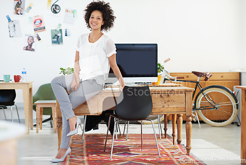 Image of Entrepreneur, office and portrait of woman Designer or small business worker happy for company growth sitting on desk. Creative, computer and employee or manager smile in a fashion agency or startup