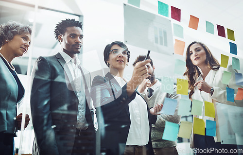 Image of Business people, team and glass board with writing, brainstorming and talking for solution, idea or goal. Group, strategy and focus with concentration for proposal, project and teamwork in workplace