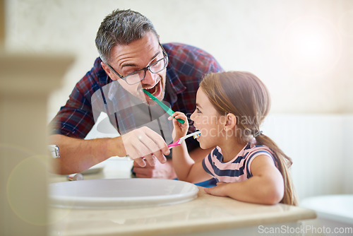 Image of Kid, father and brushing teeth in bathroom, bonding and cleaning together. Dad, girl and toothbrush for dental hygiene, oral wellness or health for happy family care, teaching and learning at home.