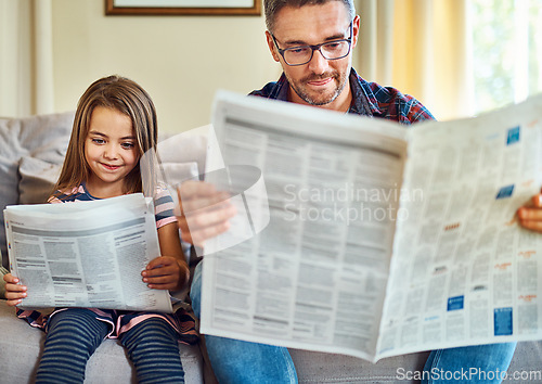 Image of Happy father, daughter and reading newspaper on sofa for knowledge, literature or news in living room at home. Dad, child and smile for family bonding, learning or education on lounge couch together
