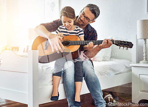 Image of Bedroom, teaching and guitar with father, girl for fun with music at the house for bonding. Instrument, acoustic and learning with parent, child in room with happiness or love or creativity at house.