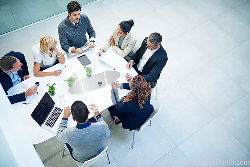 Image of Top view, business people and staff in a meeting, feedback or conversation for report on a project, discussion or budget planning. Group, men or women with ideas, teamwork or cooperation with support