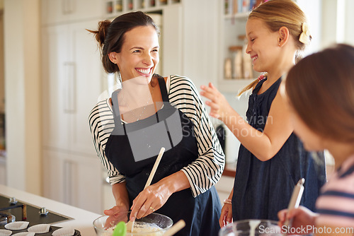 Image of Mother, family or happy kids baking in kitchen with siblings learning cookies recipe or mixing pastry at home. Laughing, funny or mom helping or teaching children to bake together for cooking skills