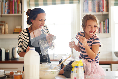 Image of Mother, play or child baking in kitchen as a happy family with an excited girl learning cookies recipe. Cake, daughter laughing or funny mom helping or teaching kid to bake with smile for development