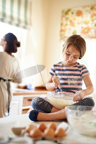 Image of Mom, mixing or girl child baking in kitchen as a family with kid learning cookies pastry recipe at home. Blur, cooking independence or baker helping or teaching child to bake for skills development