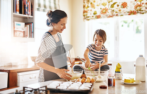Image of Mom cooking or girl child baking in kitchen as a family with a young kid learning cookies recipe at home. Cake pastry, baker or happy mother helping or teaching daughter to bake for skill development