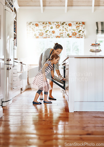 Image of Food, mother with her child baking and in the kitchen of their home with a lens flare. Happy family or bonding time, bake or cook and woman with girl at the oven prepare a meal for lunch together