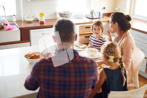Image of Happy family, morning and eating breakfast on kitchen for meal or bonding time together at home. Mother, father and children with healthy food to start the day for nutrition or cereal in the house