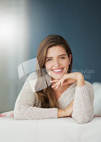 Image of Smile, portrait and woman relax on sofa in home living room on holiday. Face, happy and young female person from Canada on couch in lounge, apartment or house to enjoy mockup space and lens flare.