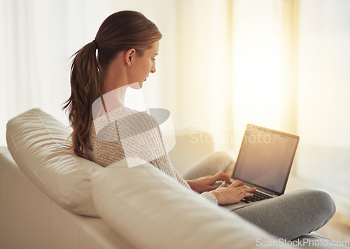 Image of Laptop, remote work and woman typing on sofa in home living room. Computer, freelancer and professional on couch in lounge writing blog, copywriting or working on project, email and internet research