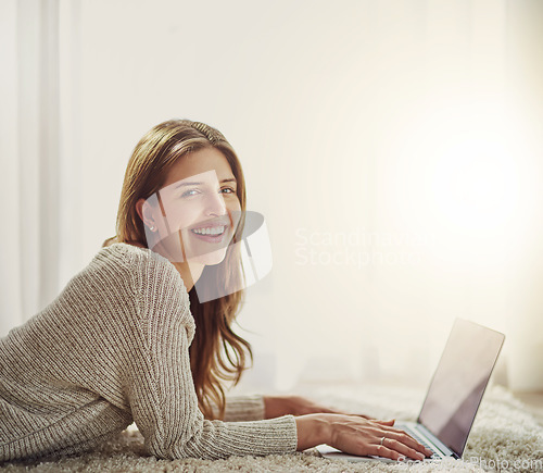 Image of Laptop, smile and portrait of woman on carpet in home, relax and lying on floor. Computer, happy face and person on ground typing, writing blog for social media or email, internet or web mockup space